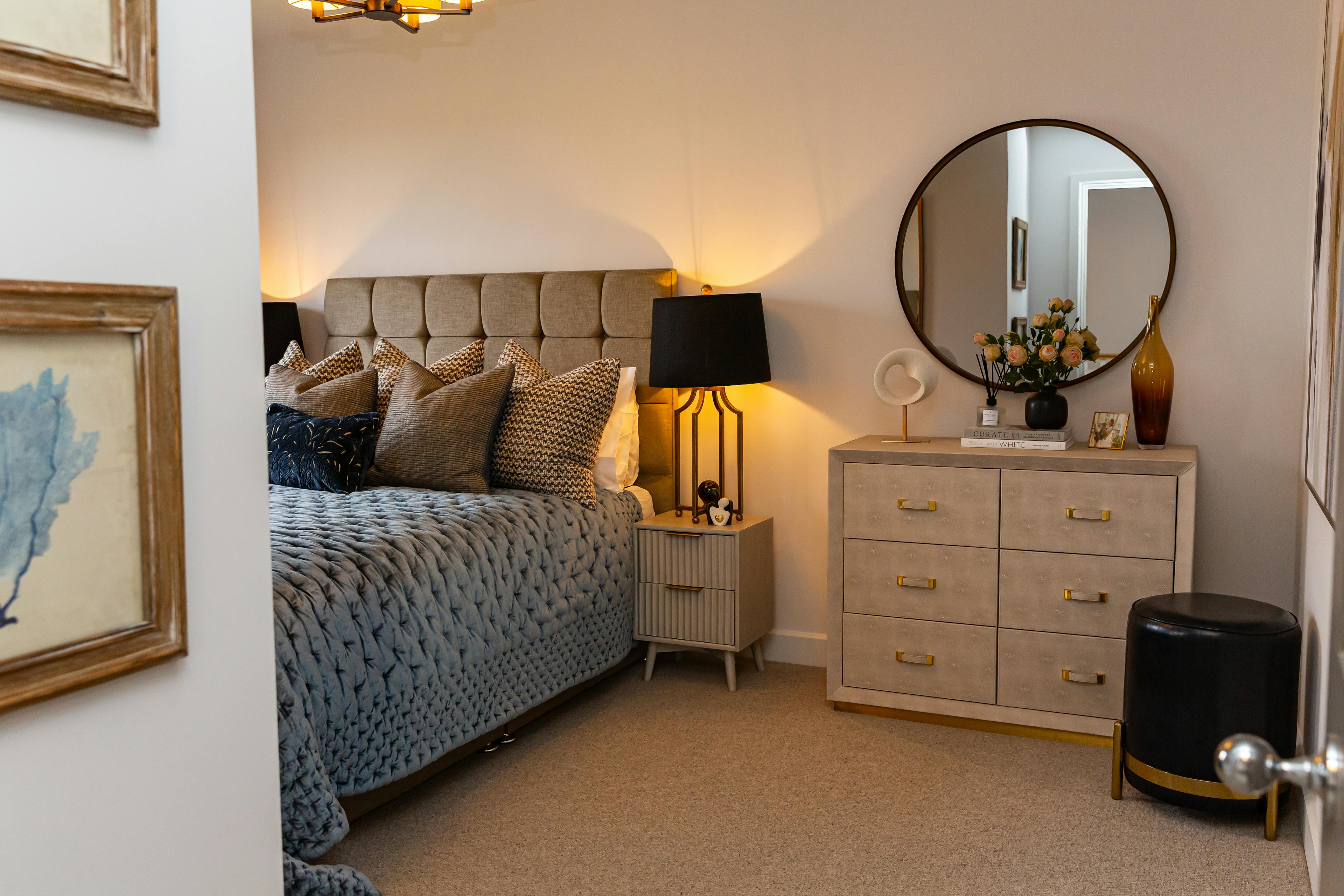 Caption: a bed room with a neatly made bed and a mirror