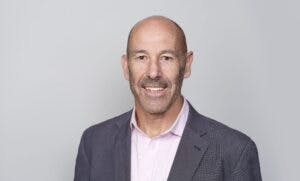 Caption: a man wearing a suit and pink shirt