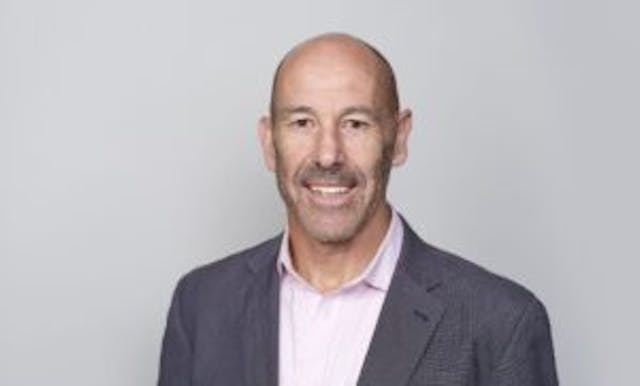 Caption: a man wearing a suit and pink shirt