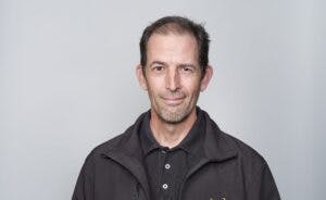 Caption: a man in a black jacket is holding a banana