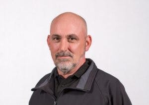 Caption: a man with a bald head wearing a black jacket