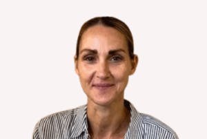 Caption: a woman in a striped shirt smiles at the camera