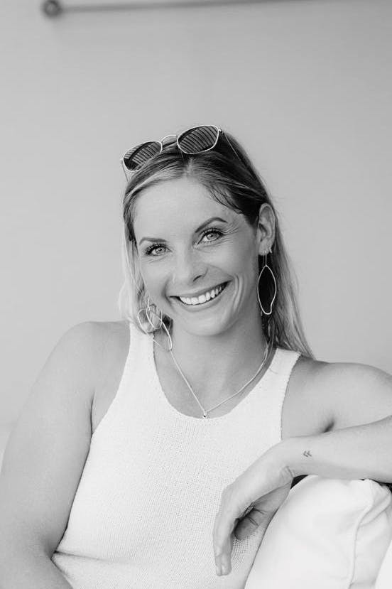 Caption: a black and white photo of a woman sitting on a bed
