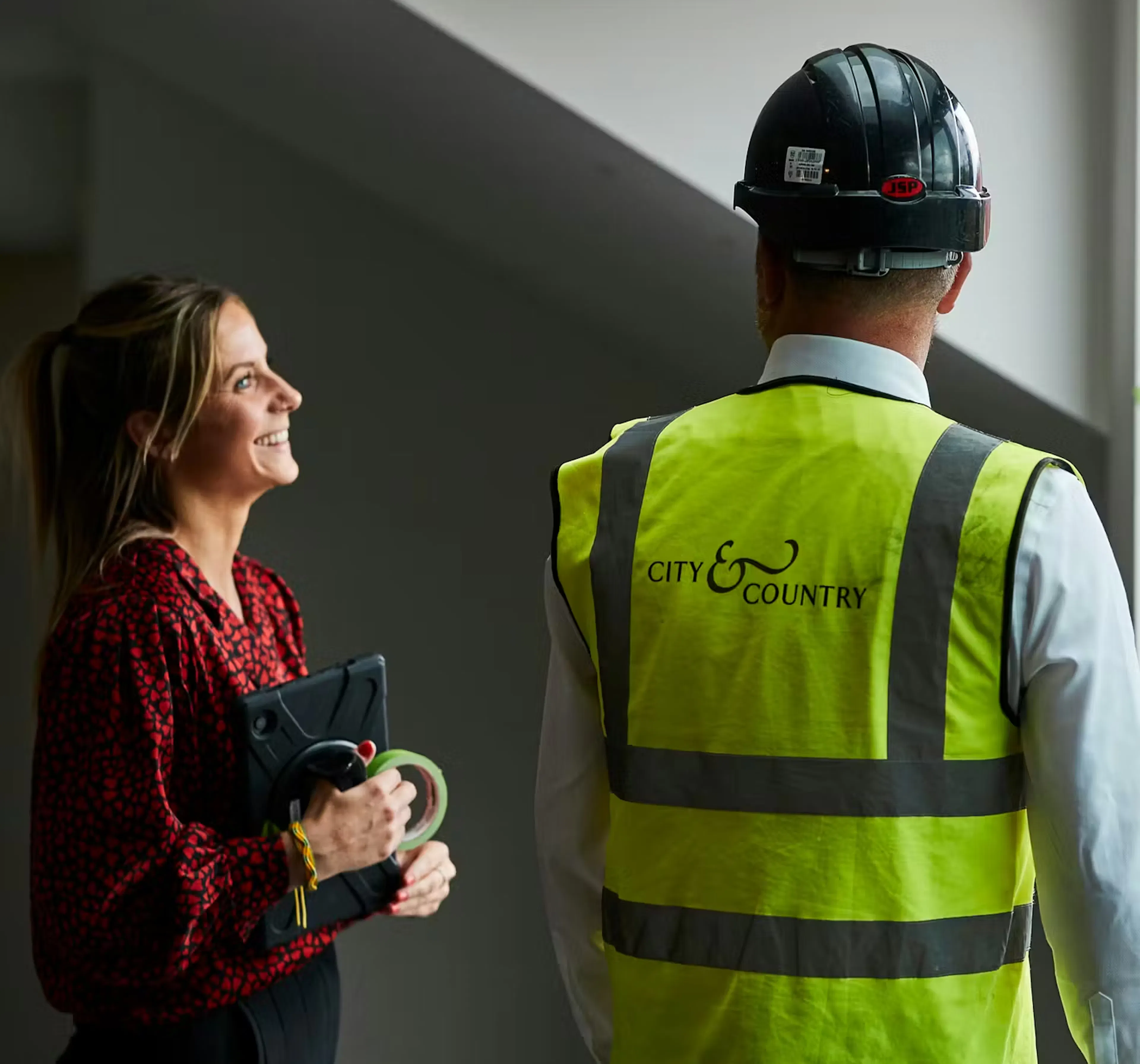 Caption: a man and a woman wearing safety vests and hard hats