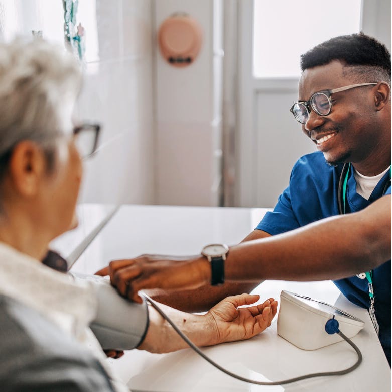 Image of a provider checking the blood pressure of person at home.