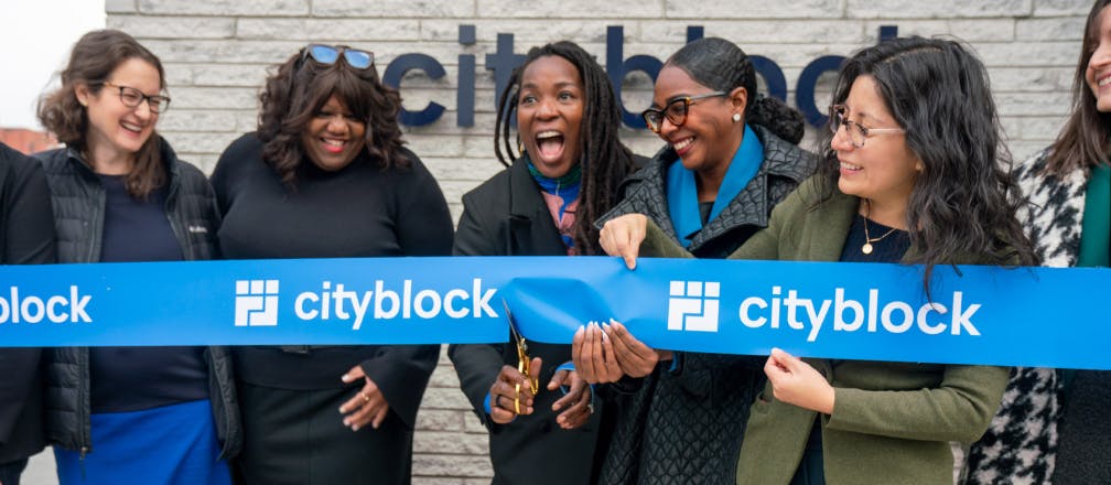 Group of women cutting Cityblock branded ribbon at a grand opening.