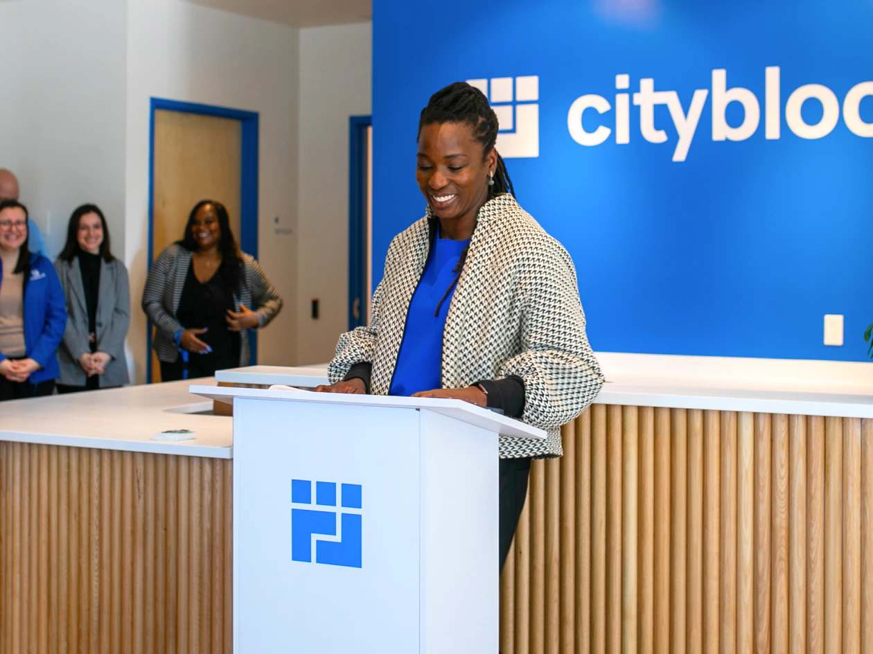 Image of Cityblock founder and CEO, Toyin Ajayi, standing and speaking at a podium.