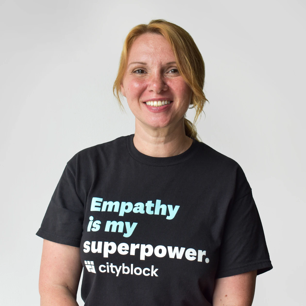 Image of a nurse care manager wearing a black Cityblock t-shirt that reads "Empathy is my superpower."