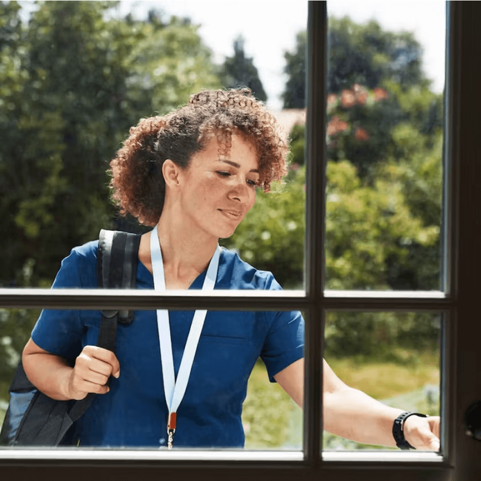 Cityblock worker rings the bell on front door with a glass window.