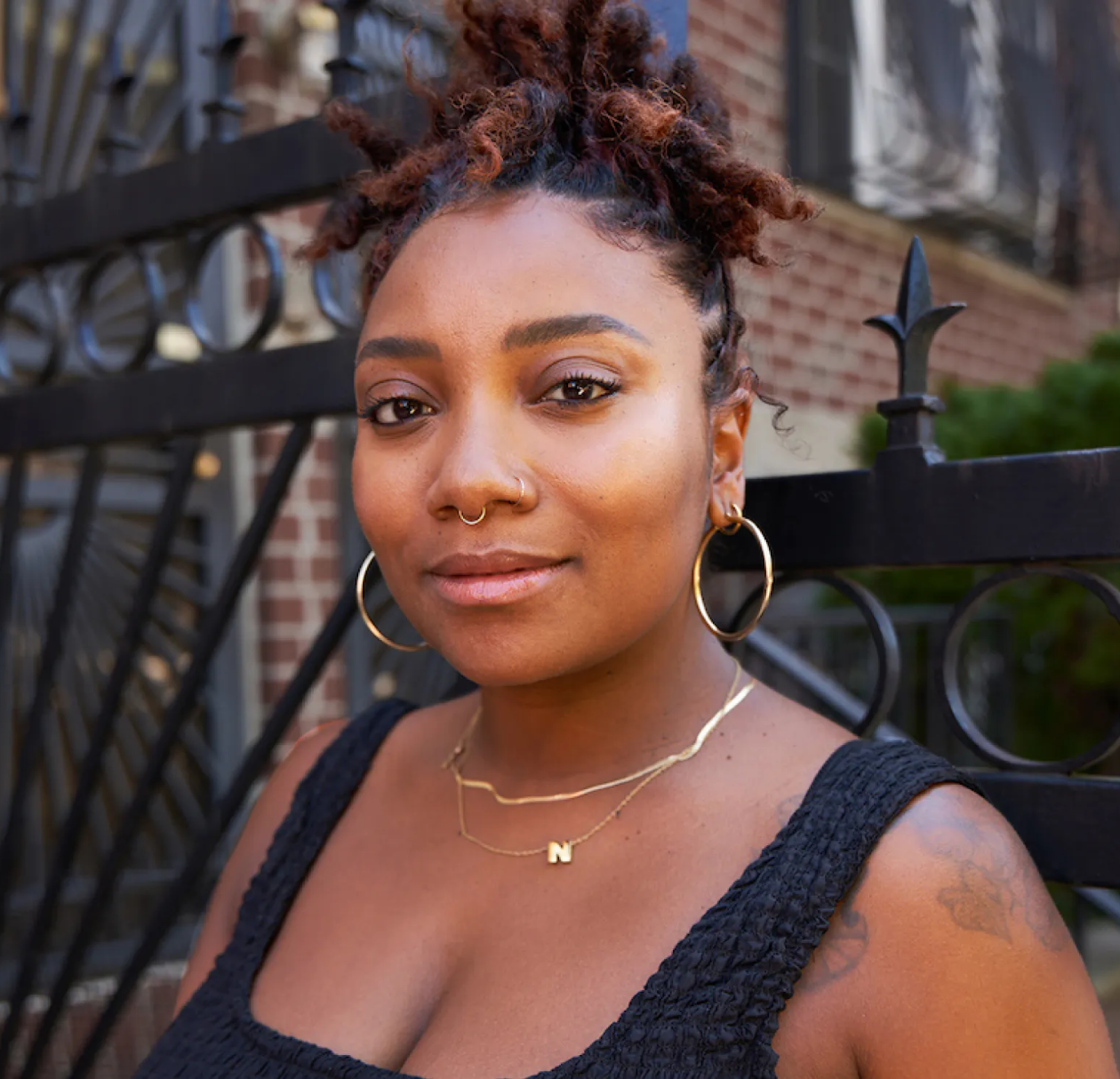Portrait image of black woman looking optimistic outside of home.