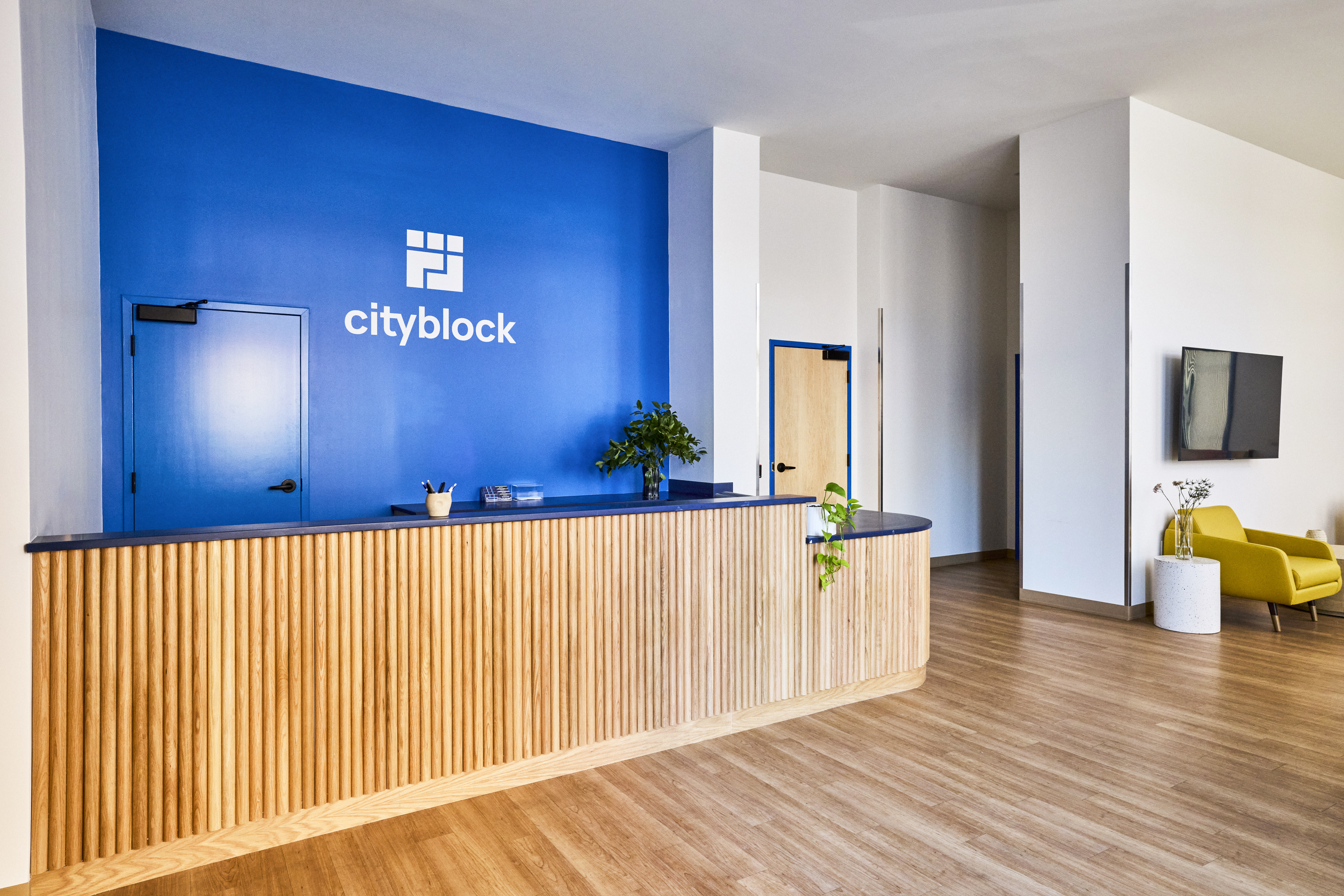 Front desk with Cityblock logo sign on blue wall.