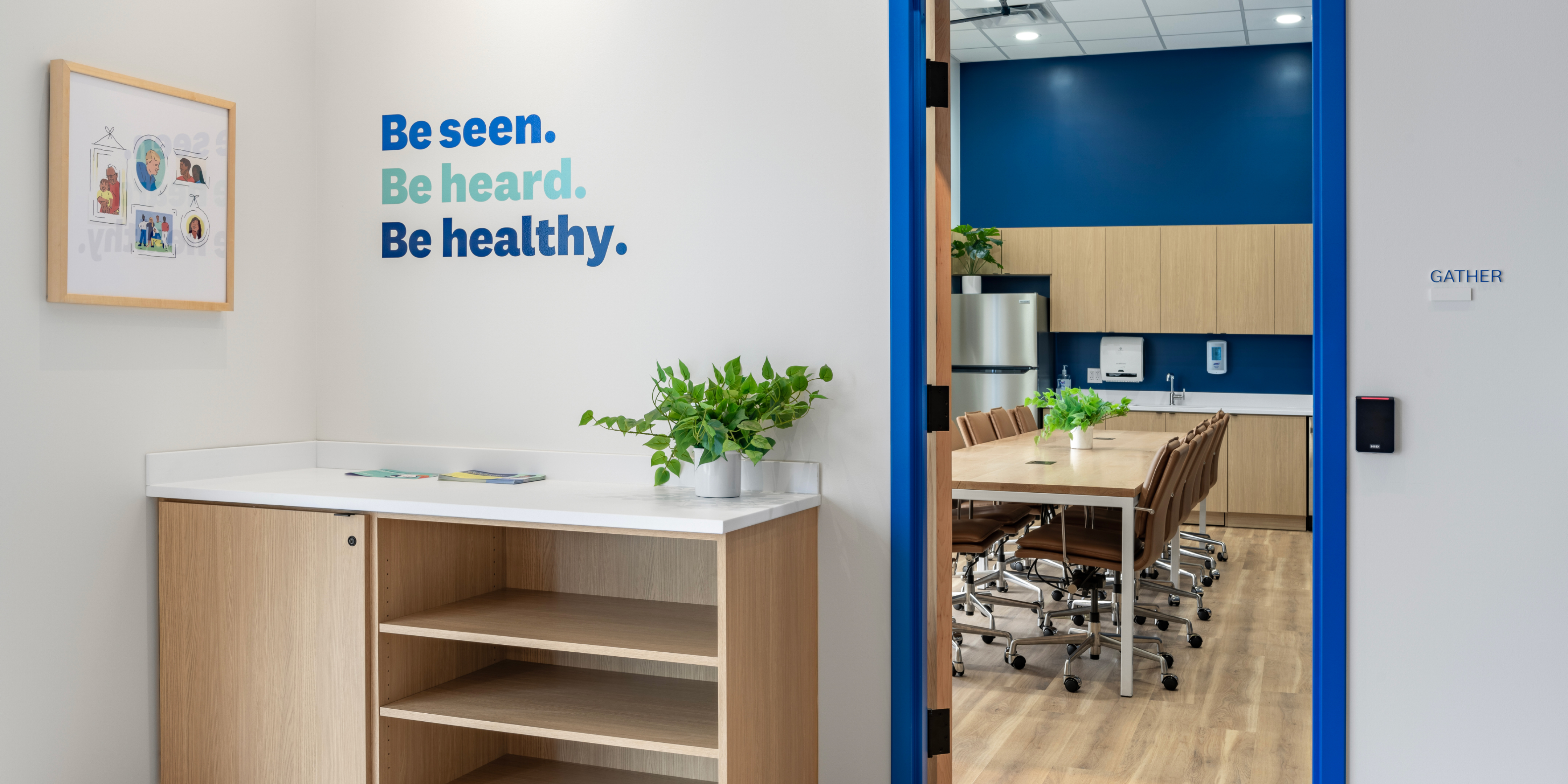 Exterior of community gather room with a while wall and letter art that says Be Seen, Be Heard, Be Healthy.