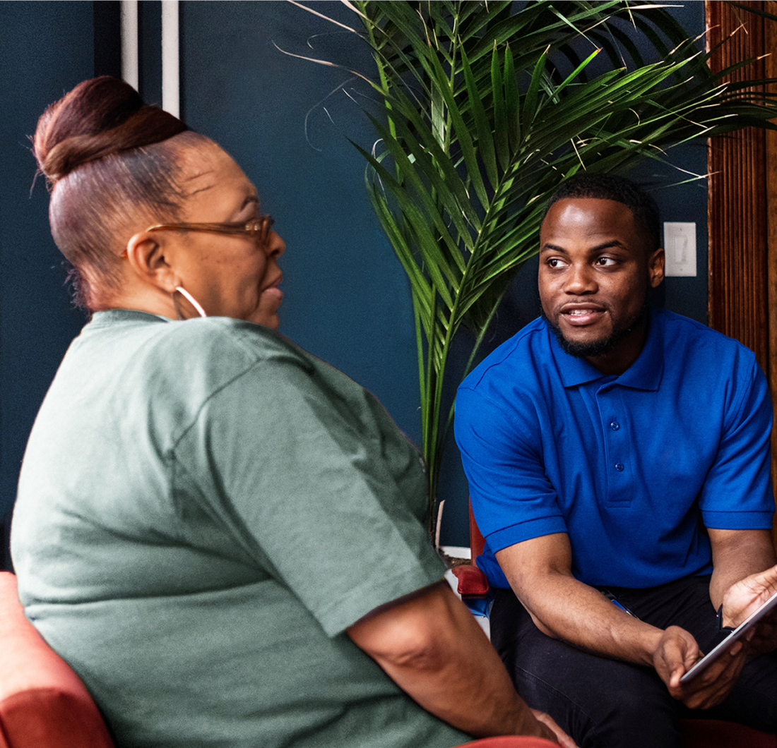 Cityblock employee with blue shirt shows iPad to member.