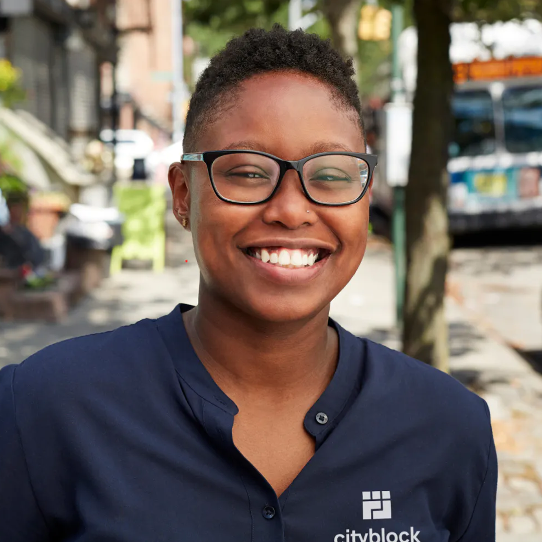 Photo of Cityblock employee in a navy shirt and glasses smiling