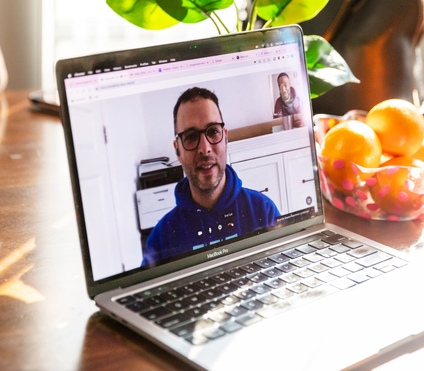 Photo of laptop computer and a person on a video call