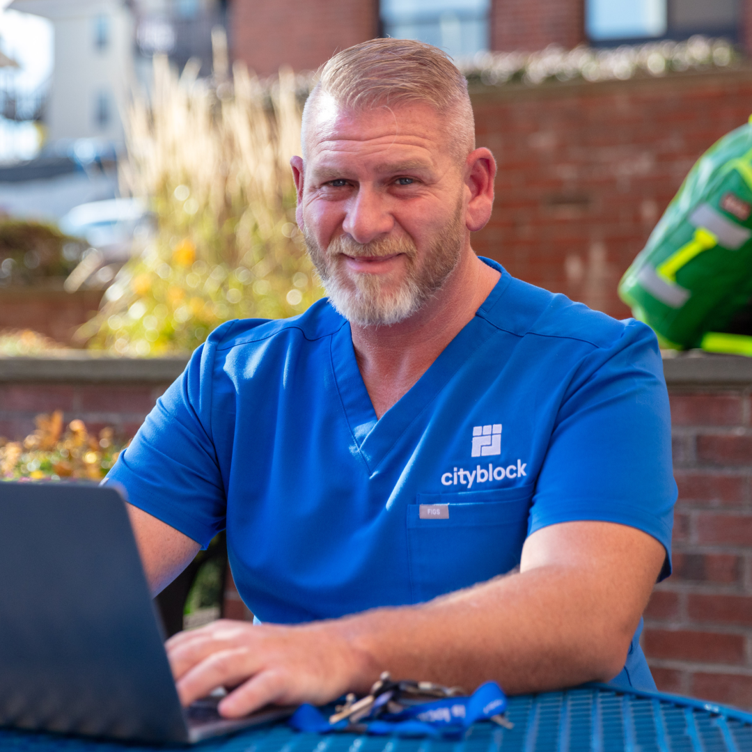 Photo of a Cityblock provider typing on a laptop computer in an outside space