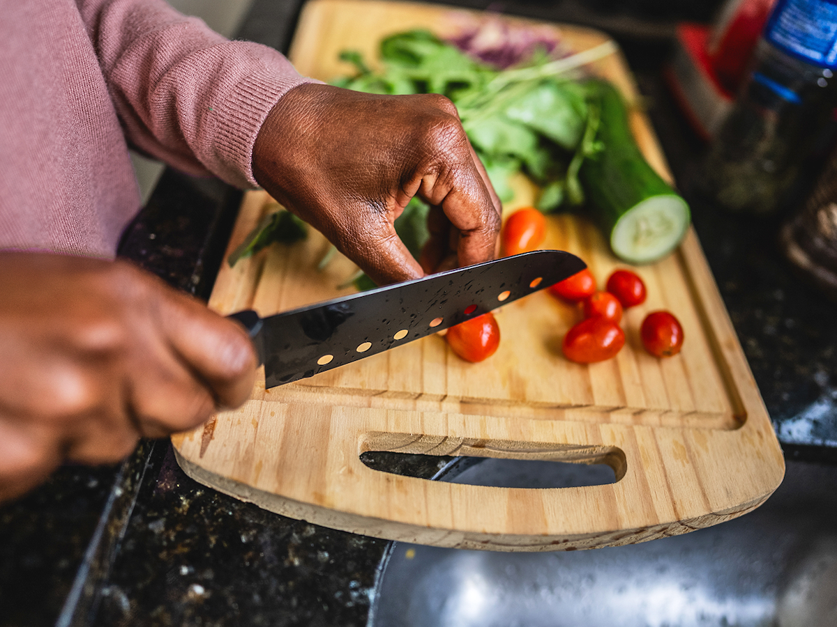 Photo of a person chopping vegetables on a cutting board
