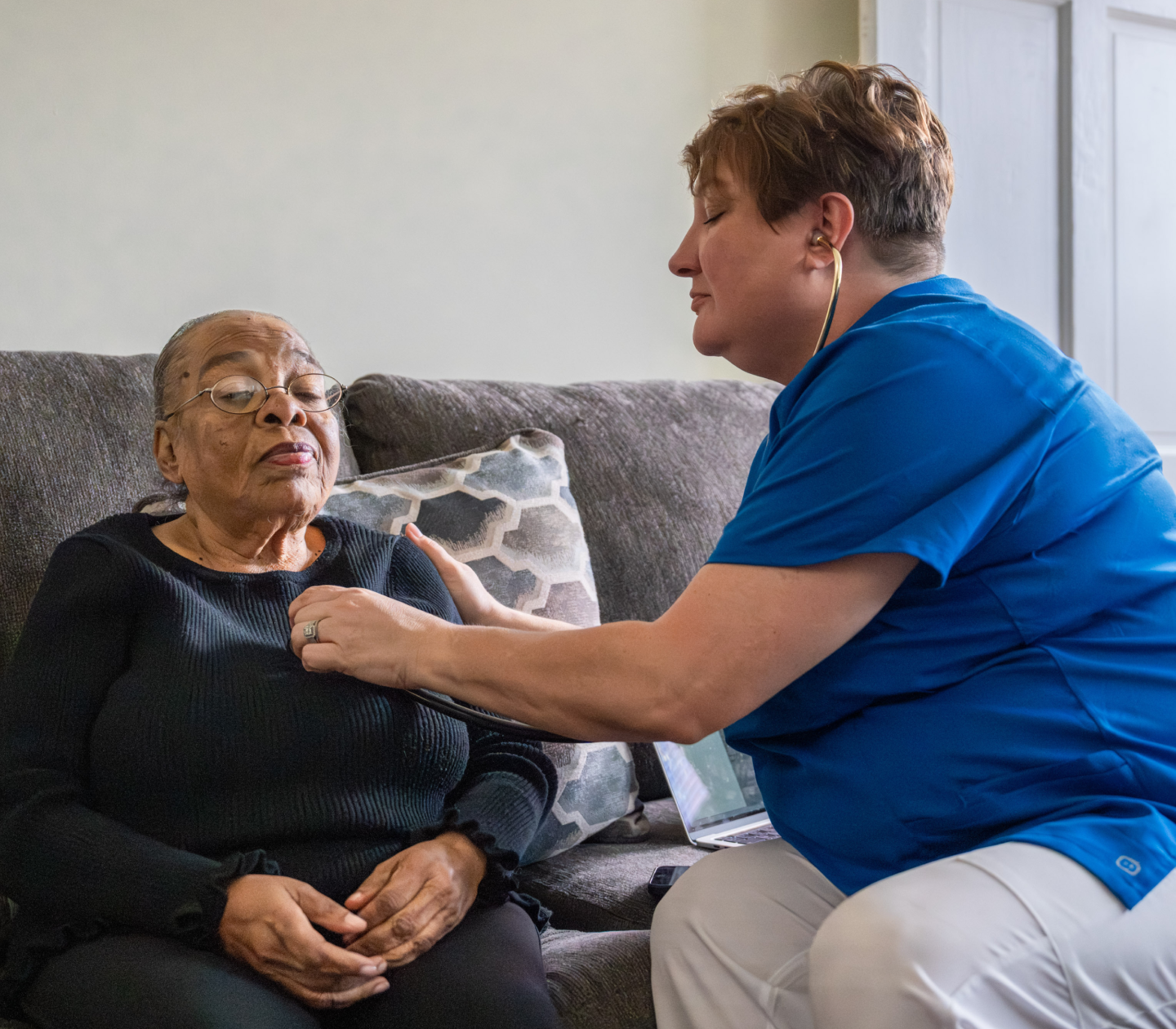 Cityblock urgent care provider checks member's heart rate with a stethoscope at home.