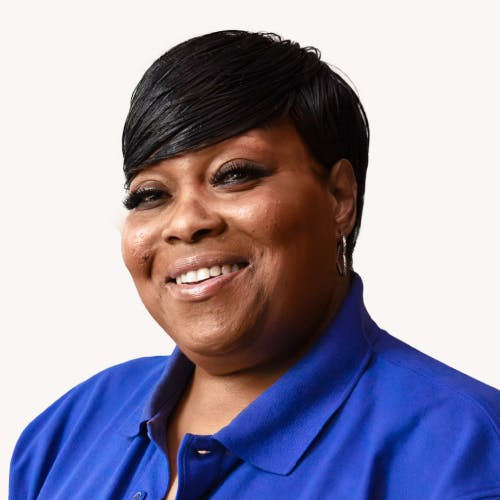 Woman smiles proudly wearing a blue polo.