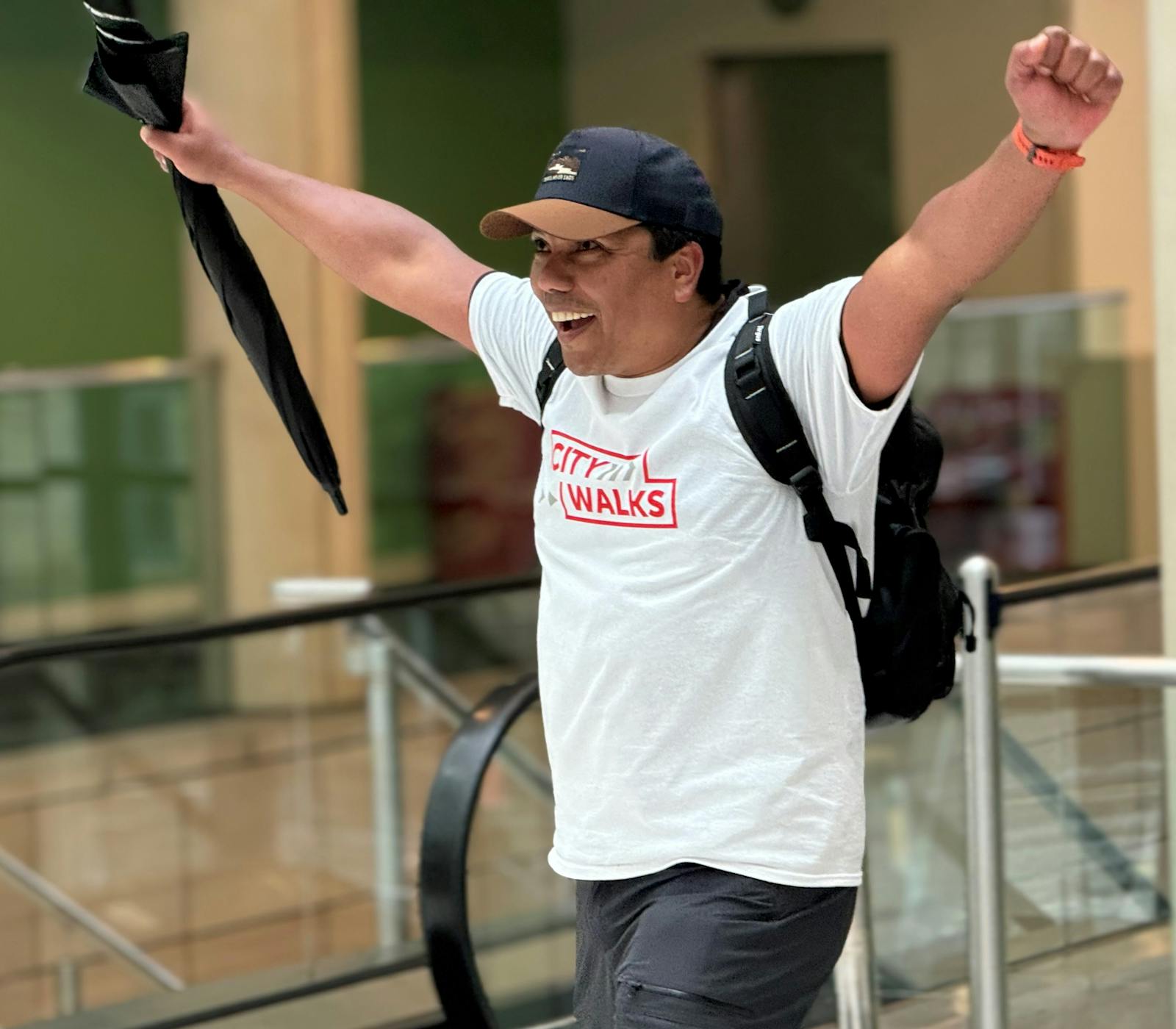 One City Walker in his Crisis t-shirt, smiling and holding his arms in the air triumphantly.