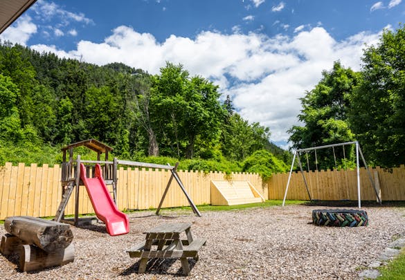 Kinderspielplatz mit Schaukeln und Rutsche - Camping Alpenblick