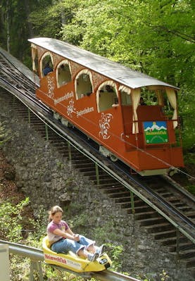 Drahtseilbahn im Hintergrund mit Rodlerin im Vordergrund