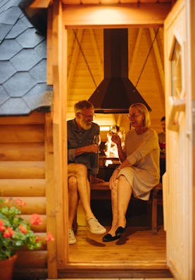 Eine Frau und ein Mann trinken Wein im Grill House Woodstöckli - Camping Alpenblick