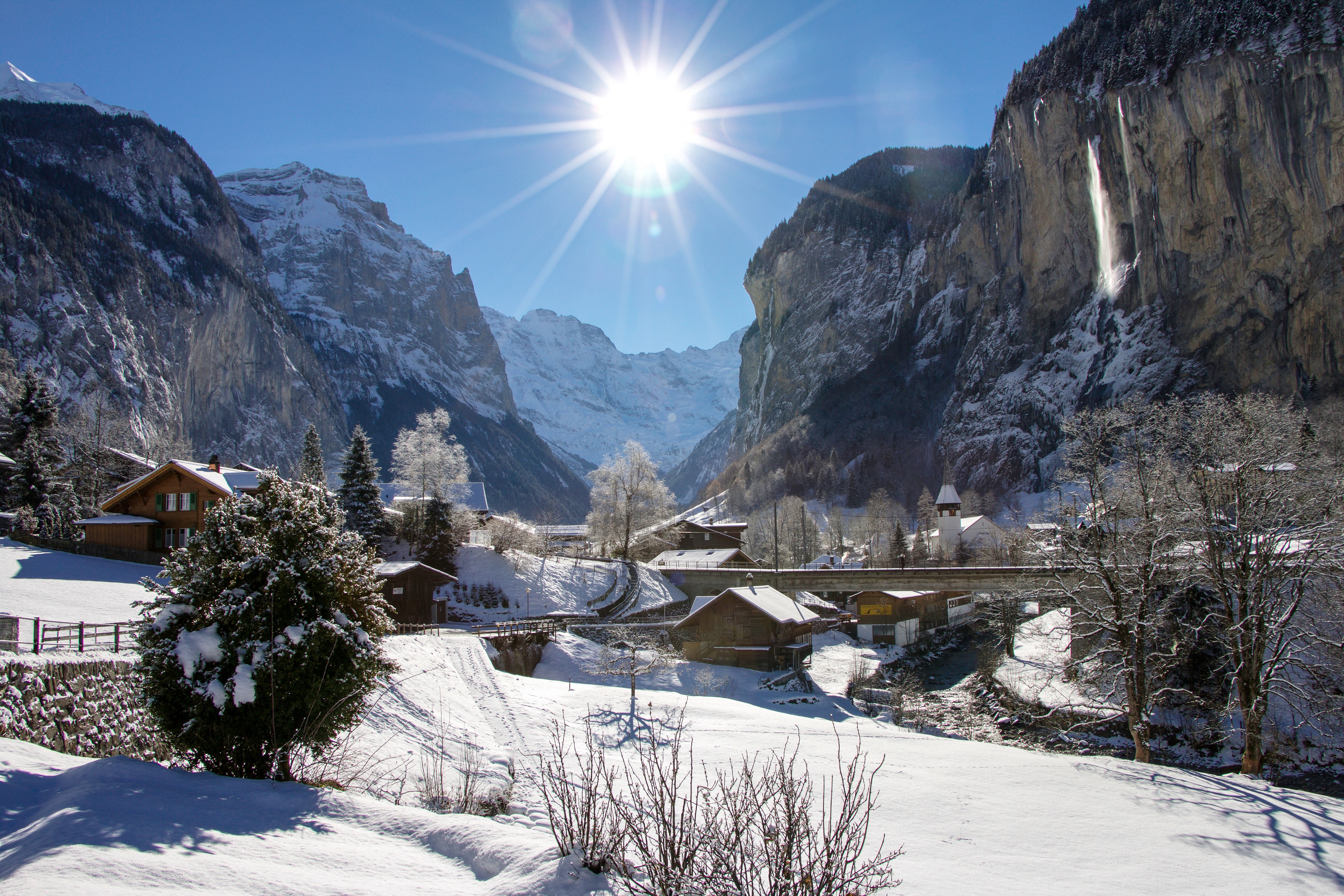 Lauterbrunnen im Winter mit schneebedeckten Wiesen und blauem Himmel