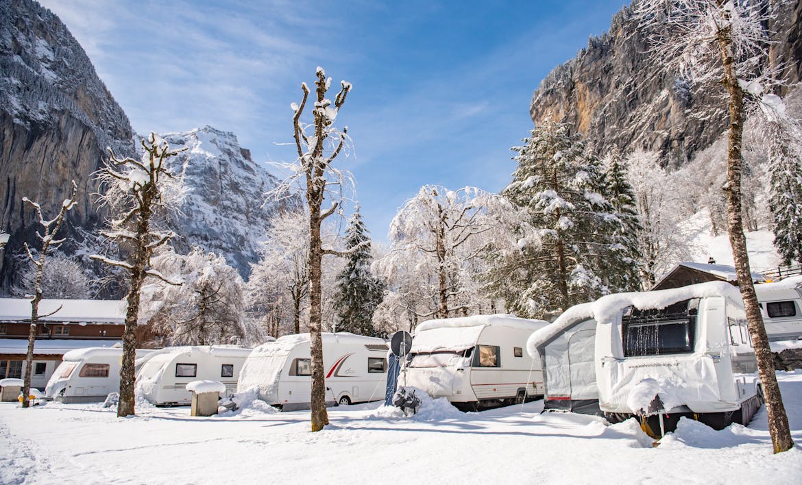 caravans covered in snow in a winter landscape at Camping Jungfrau