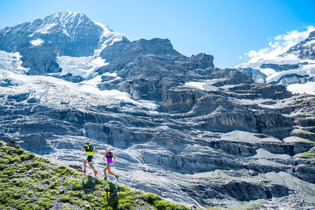 zwei Trailrunner beim Aufstieg auf dem Weg nach Grindelwald mit beeindruckenden Bergen im Hintergrund