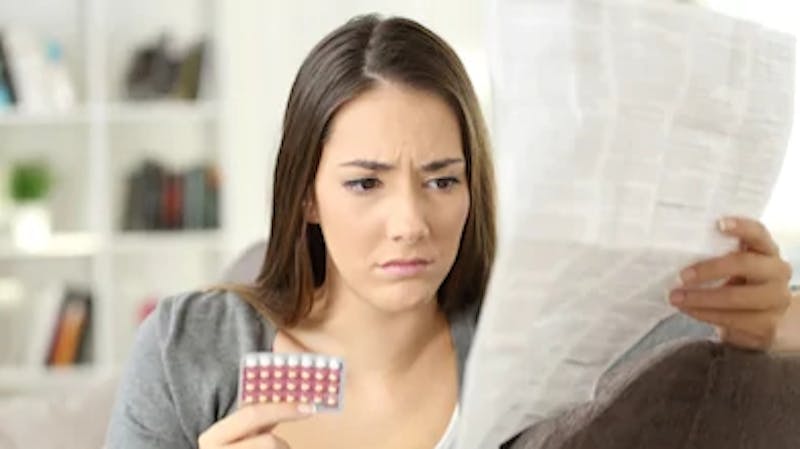 Contraception: A woman taking contraceptive pills