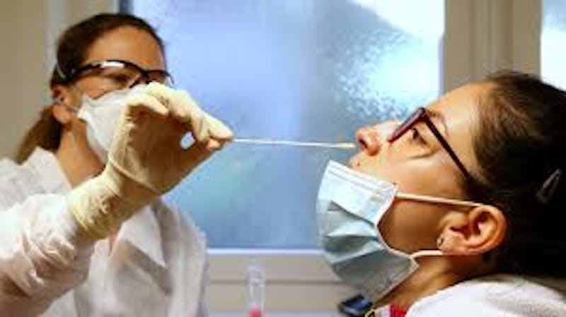 A docotor testing a patient with a nose swab