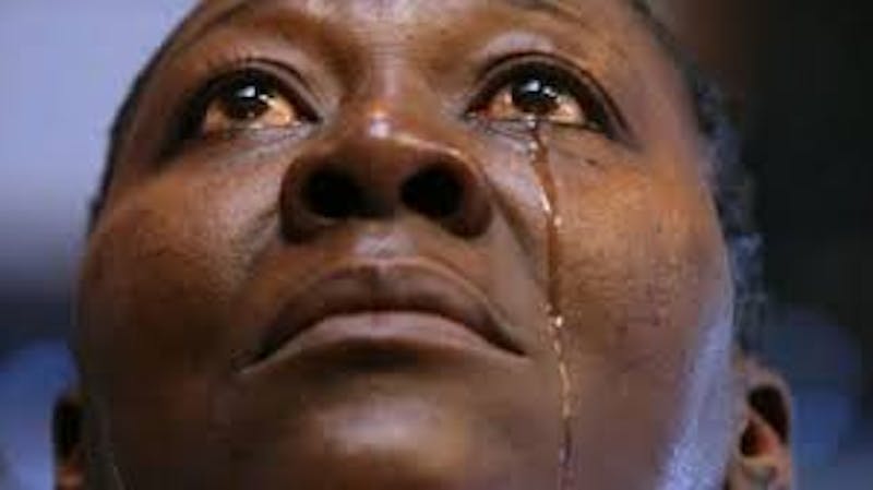 A young, black lady in deep tears after being racially abused