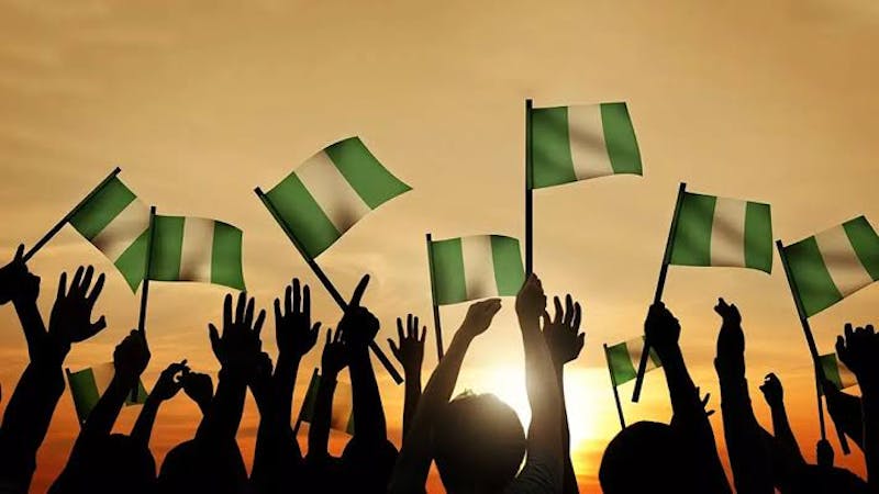 A cheering crowd bearing Nigeria flags