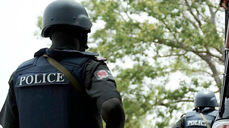 A police officer carrying gun with inscription police on his uniform