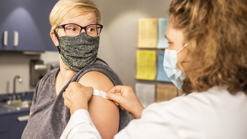 A health worker administers vaccines to a patient.