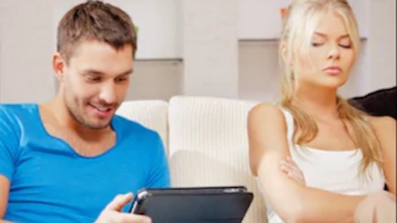 A lady annoyed and showing signs of jealousy as her boyfriend texts another woman
