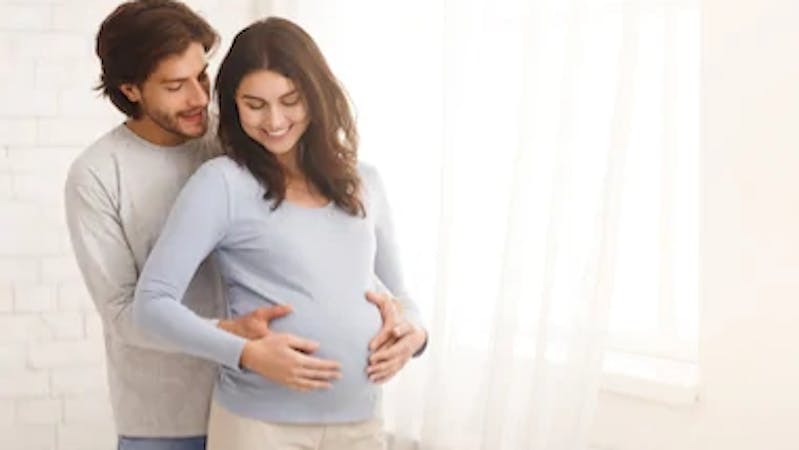 A man holding his pregnant wife affectionately