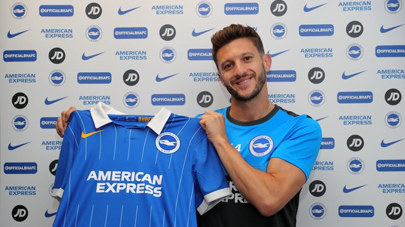 Adam poses with Brighton's Jersey after signing for the club