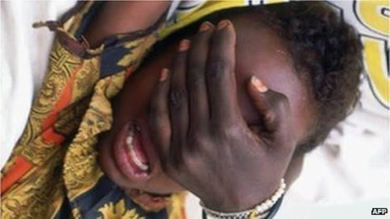 Female genital mutilation: A woman holding down a girl child in readiness for FGM