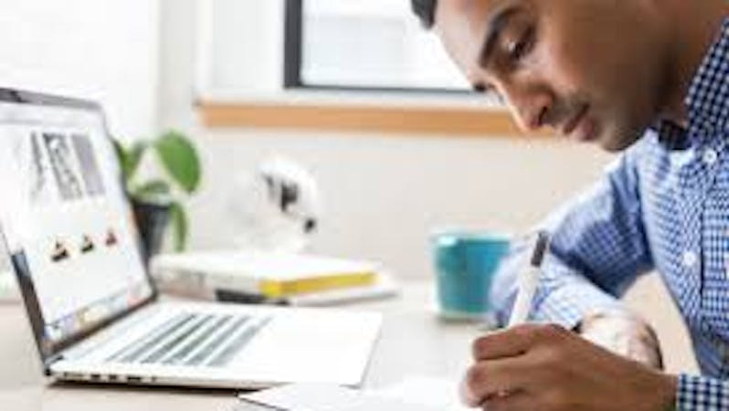 A man that is jotting down different websites to follow.