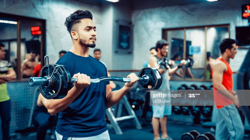 Young men carrying lift during workouts in a gym