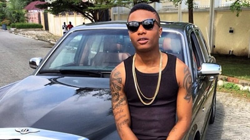 Wizkid posses with one of his cars