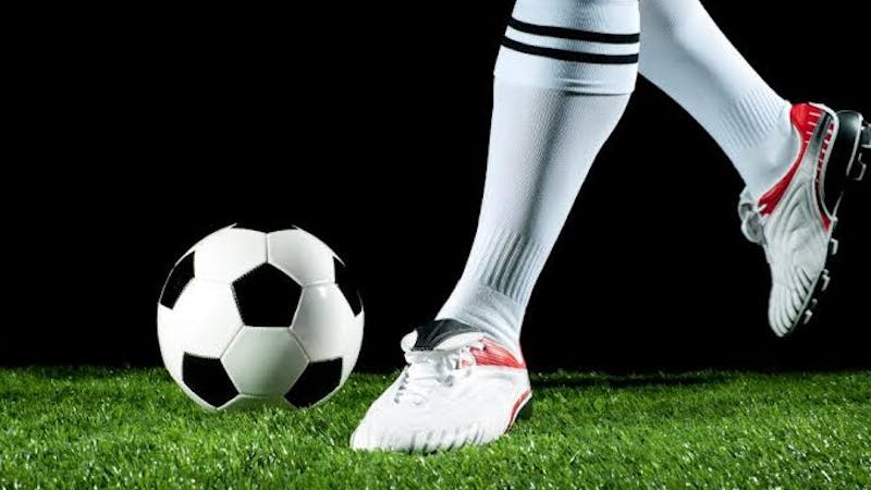 Close up soccer player kicking a football