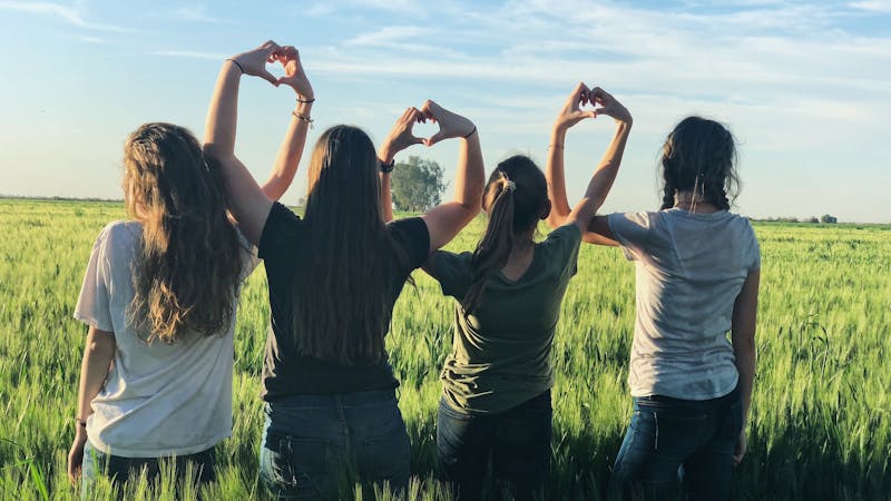 Young people holding hands together.