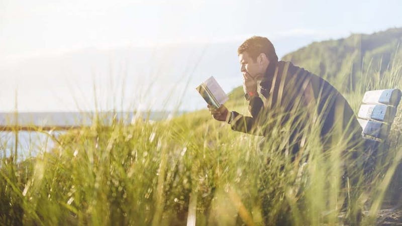 A young man employing skimming and scanning while reading