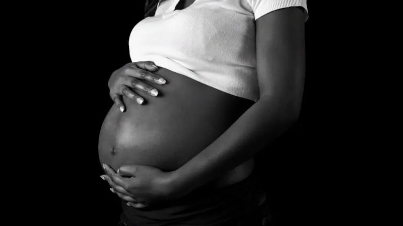 A pregnant woman holding up her belly
