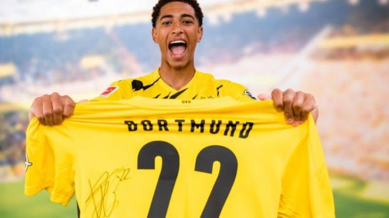 Jude Bellingham holding the number 22 shirt after signing for Dortmund