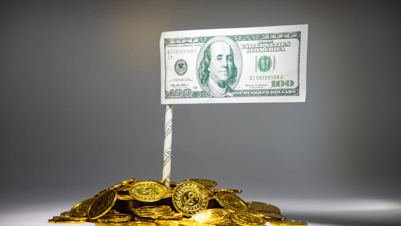 A stash of Coins with 100 dollar bill.