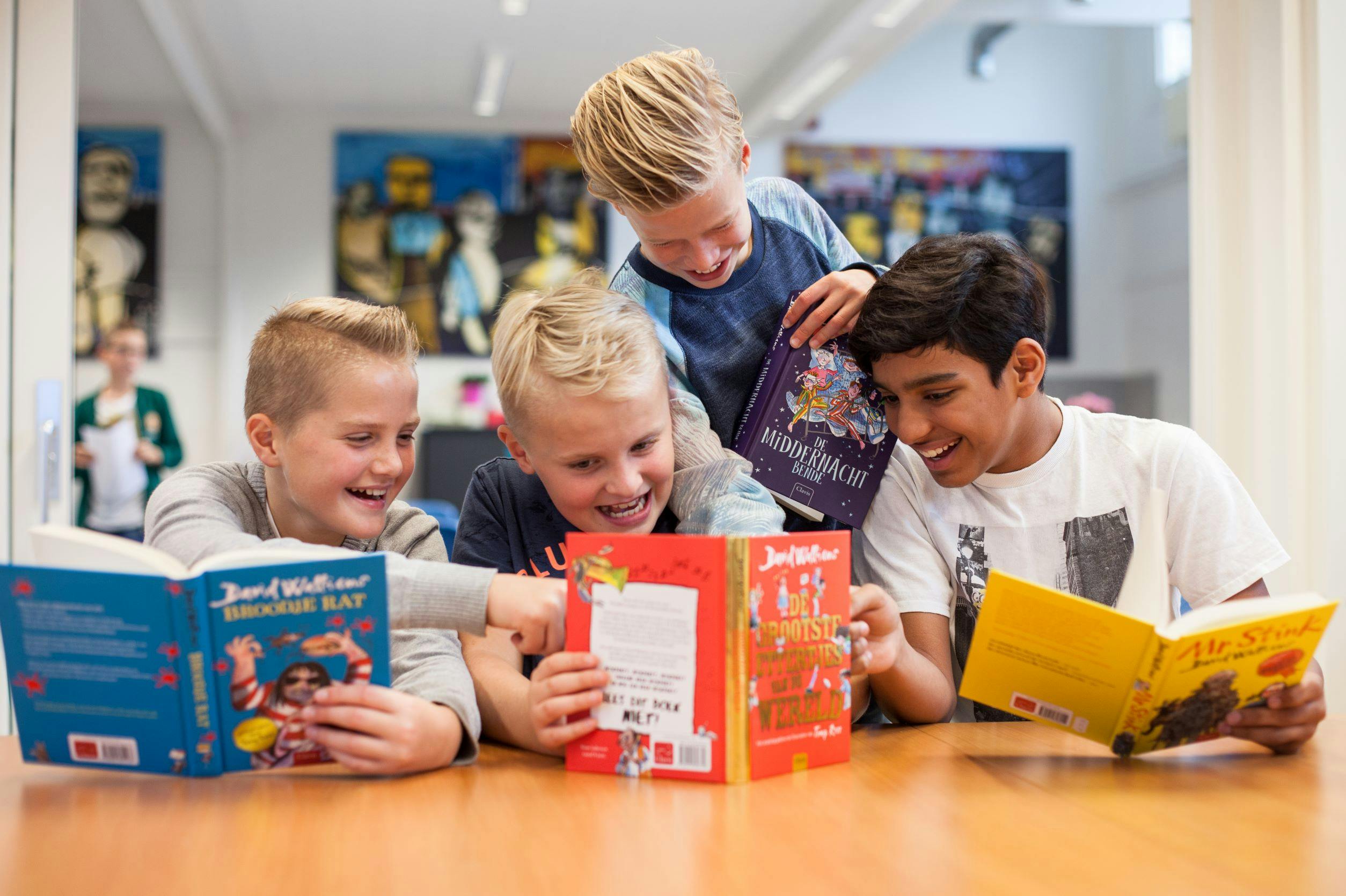 4 jongens lezen een boek van David Walliams in de klas: Broodje rat, De grootste ettertjes van de wereld, Mr Stink en De middernacht bende